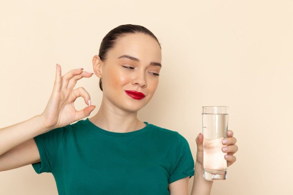 mujer sonriendo vaso agua gesto ok hidratacion
